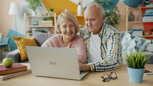 Couple de seniors consultant un guide sur ordinateur
