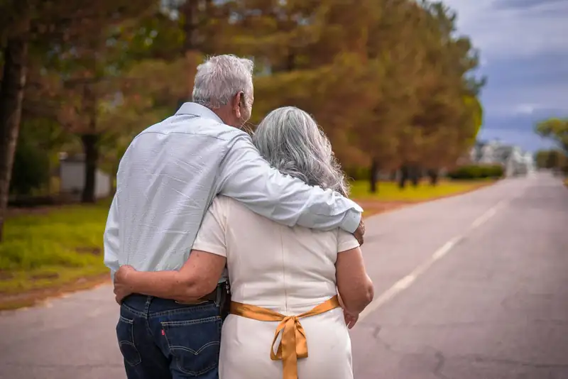 Couple âgé se promenant bras dessus bras dessous